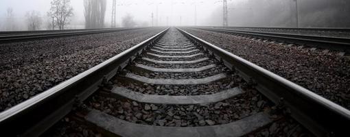 The railway track in a misty morning. A lot of rails and sleepers go into the misty horizon. Fisheye photo with increased distortion