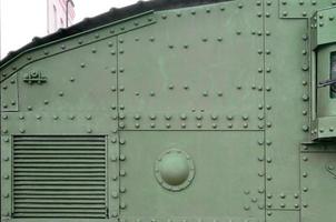 Texture of tank side wall, made of metal and reinforced with a multitude of bolts and rivets photo