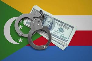 Comoros flag with handcuffs and a bundle of dollars. Currency corruption in the country. Financial crimes photo