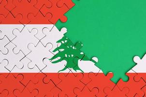 Lebanon flag is depicted on a completed jigsaw puzzle with free green copy space on the right side photo