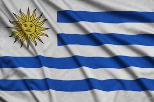 Uruguay flag is depicted on a sports cloth fabric with many folds. Sport team banner photo