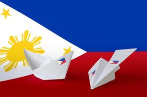 Philippines flag depicted on paper origami airplane and boat. Handmade arts concept photo