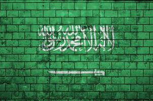 la bandera de arabia saudita está pintada en una vieja pared de ladrillos foto