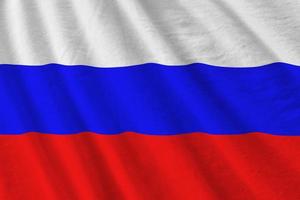 Russia flag with big folds waving close up under the studio light indoors. The official symbols and colors in banner photo