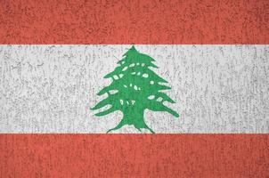 Lebanon flag depicted in bright paint colors on old relief plastering wall. Textured banner on rough background photo