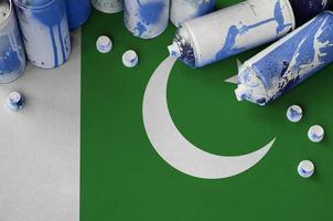 Pakistan flag and few used aerosol spray cans for graffiti painting. Street art culture concept photo