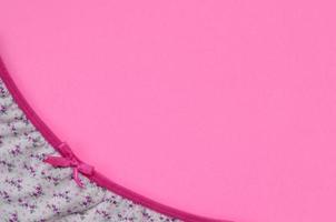 cinta en ropa interior de mujer blanca con encaje sobre fondo rosa con espacio de copia. concepto de blogger de moda de belleza. lencería romántica para la tentación del día de san valentín foto