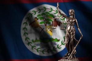Belize flag with statue of lady justice and judicial scales in dark room. Concept of judgement and punishment photo