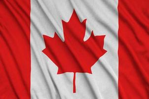 Canada flag is depicted on a sports cloth fabric with many folds. Sport team banner photo