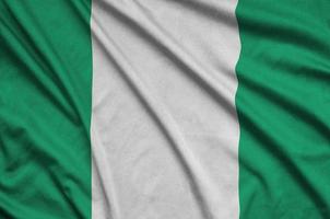 Nigeria flag is depicted on a sports cloth fabric with many folds. Sport team banner photo
