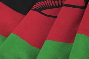 bandera de malawi con grandes pliegues ondeando de cerca bajo la luz del estudio en el interior. los símbolos y colores oficiales en banner foto