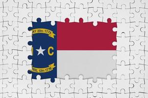 North Carolina US state flag in frame of white puzzle pieces with missing central part photo