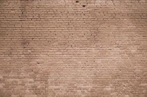 The texture of the brick wall of many rows of bricks painted in brown color photo