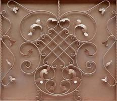 The texture of the bronze metal gate with a beautiful floral pattern of forged metal photo