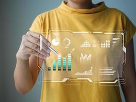 Data analysis concept. Female analyst is analyzing data from graphs on a virtual screen. photo