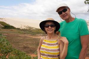 Couple standing in front of the Sand Dunes that are in Combuco, Brazil in the State of Ceara photo