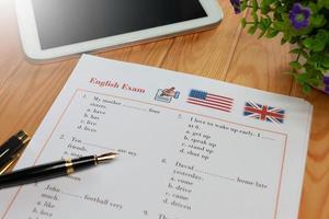 prueba de inglés con bolígrafo sobre mesa de madera en clase foto