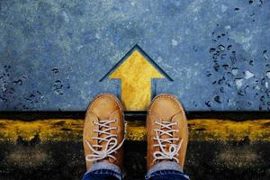 Motivation and Success Concept. Top View of Male with Leather Shoes satnding on the Crossroad to Making Decision to Steps or Stop. Forward Arrow on the Floor as background photo