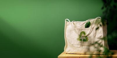 Cotton Recycling Bag on Wooden Table by Green Wall. Zero Waste Products. Environment, Ecology Care, Renewable Concept photo