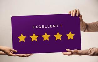 Customer Experience Concept. Happy Client giving an Excellent Five Star Rating Review on a Huge Card. Send Feedback to the Brand photo