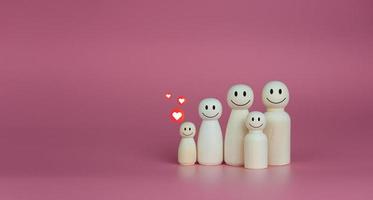 concepto de casa feliz. las muñecas de madera se alinean con iconos de corazón. indica felicidad y amor en el hogar. foto