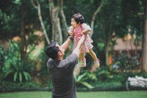 Asian enjoy happy father dad holding his daughter and having good time in autumn park. Concept of family. Father and child daughter. Happy family. photo