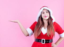 primer plano de una mujer caucásica feliz con ropa de santa sonriendo y señalando con el dedo foto