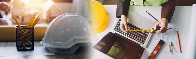 Two colleagues discussing data working and tablet, laptop with on on architectural project at construction site at desk in office photo