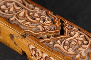 A close-up artistic wood carving on the pencil case on a black background. Central Asia, Uzbekistan photo
