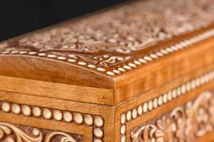 The artistic wood carving on the casket on the black background. Central Asia, Uzbekistan, close-up photo