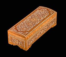 A wooden casket with traditional artistic carving isolated on a black background photo