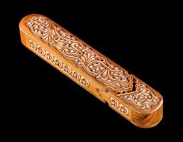 The artistic wood carving on the pencil case on a black background. Central Asia, Uzbekistan photo