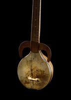 An ancient Asian stringed musical instrument on a black background photo