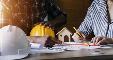 Construction engineer working at blueprint to build large commercial buildings in office. Engineering tools and construction concept. photo