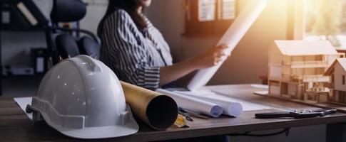 Construction engineer working at blueprint to build large commercial buildings in office. Engineering tools and construction concept. photo