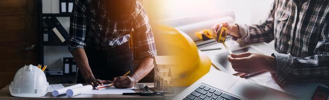 Two colleagues discussing data working and tablet, laptop with on on architectural project at construction site at desk in office photo