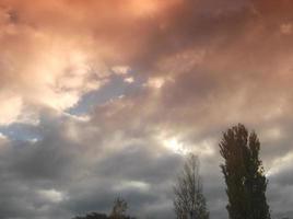 Multi-colored clouds fly over the village photo