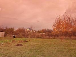 Multi-colored clouds fly over the village photo