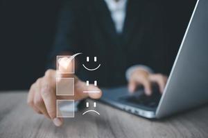 servicio al cliente y concepto de satisfacción, gente de negocios tocando la pantalla virtual en el icono de la cara de sonrisa feliz para dar satisfacción en el servicio. foto