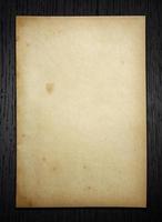 Old paper on dark wood  background with clipping path photo