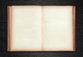 old book open on dark wood background photo