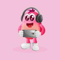 Cute pink monster playing game mobile, wearing headphones vector