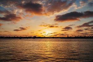 puesta de sol en el océano pacífico con silueta de palmera foto