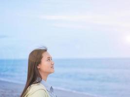 Take a shot at the head of an Asian woman walking by the sea. along the beach looking at the sky free sample release The wind blows, there is a flare. photo