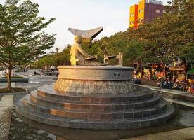 Makassar,Indonesia,2021-statue of a woman doing activities with green trees in the background photo