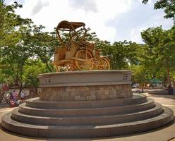 Makassar,Indonesia,21 Juni 2021-golden rickshaw statue on green plant background photo