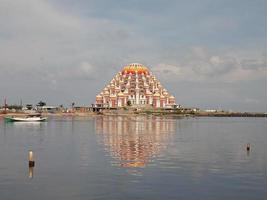 Makassar,Indonesia,31 Juni 2021-A modern mosque building in the middle of the sea with a blue sky and white clouds photo