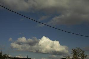 Cloud over garages. White cloud in sky. Weather in summer. photo