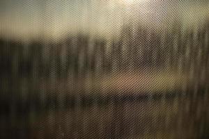 Glass surface in film. Texture of film on window. Blurry background of small waves. photo