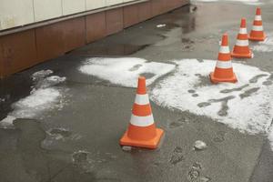 Concealing cap on asphalt. Emergency area. Snow falling from roof. photo